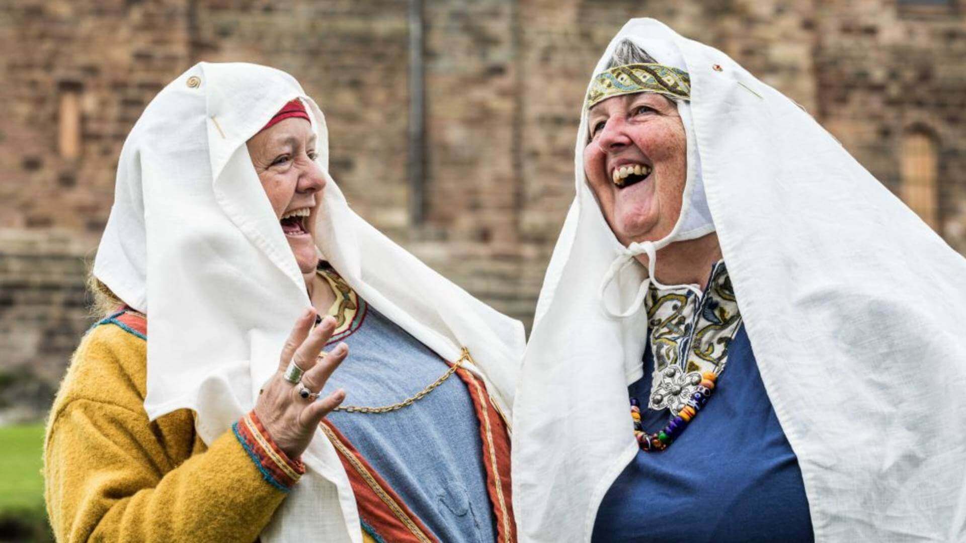 Two ladies laughing dressed in Anglo Saxon costumes