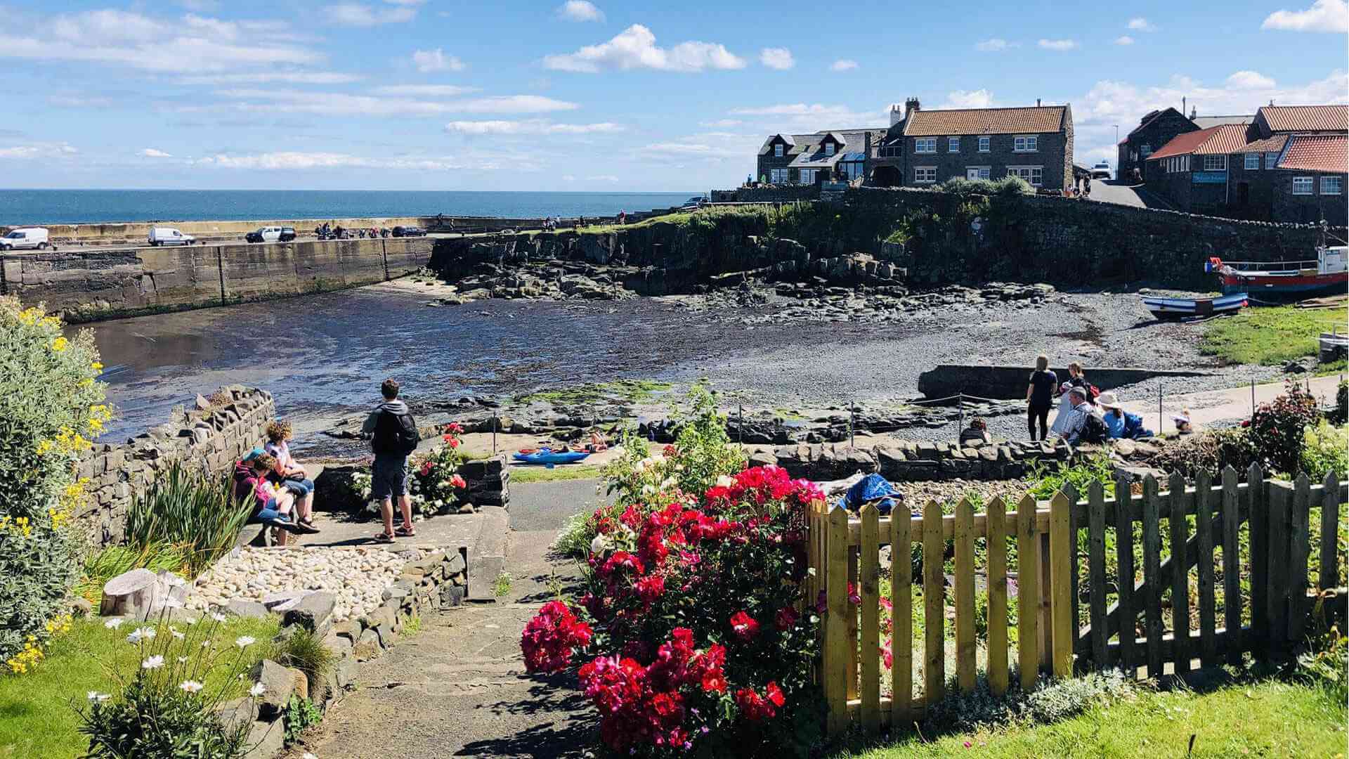 People enjoying Craster harbour