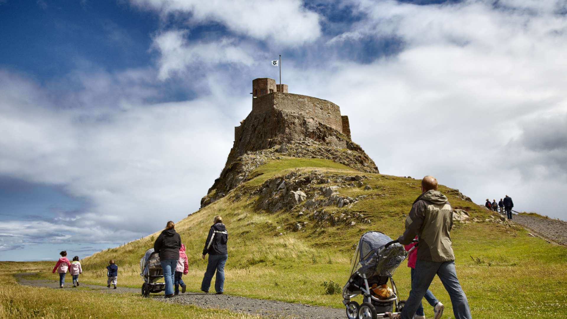 Families walking to Lindisfarne Castle